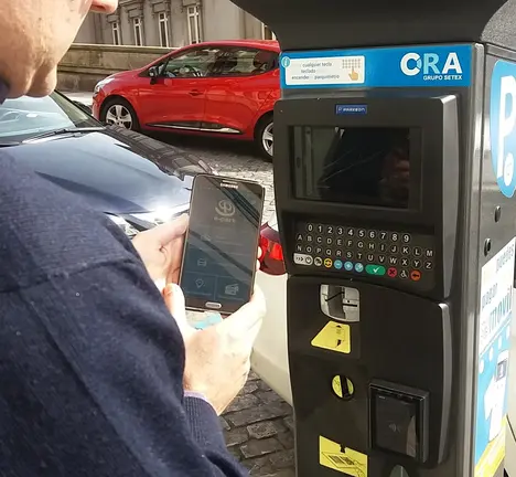 Usuario da aplicaci&oacute;n m&oacute;bil E-Park da ORA diante dun dispositivo expendedor